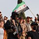 In Idlib, Syria, on May 4, protesters against Israeli strikes include a child, a man waving a Syrian flag, a masked gunman, and many others.