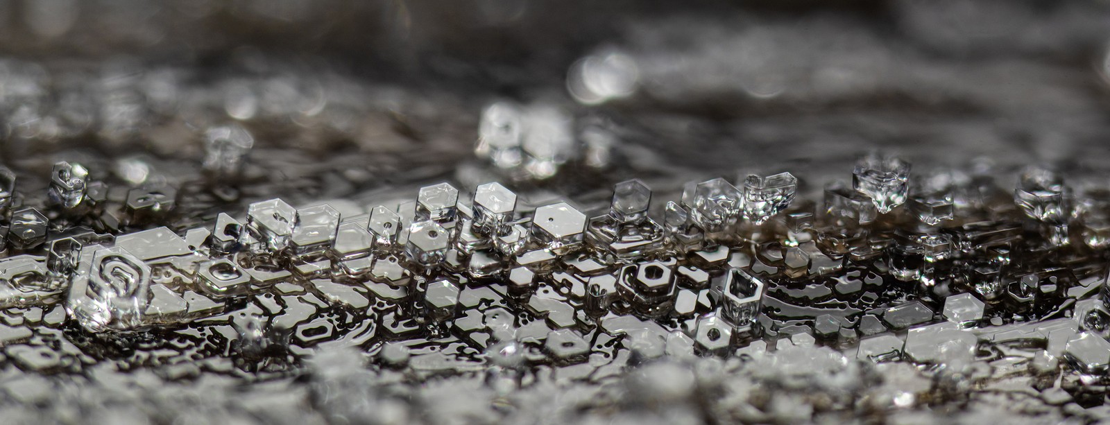 A microscopic view of frost, looking like many tiny hexagonal slabs stacked on top of each other