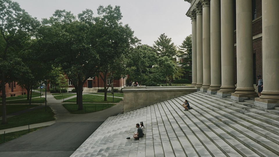 Side picture of the stairs that lead to building with greek columns in college campus.