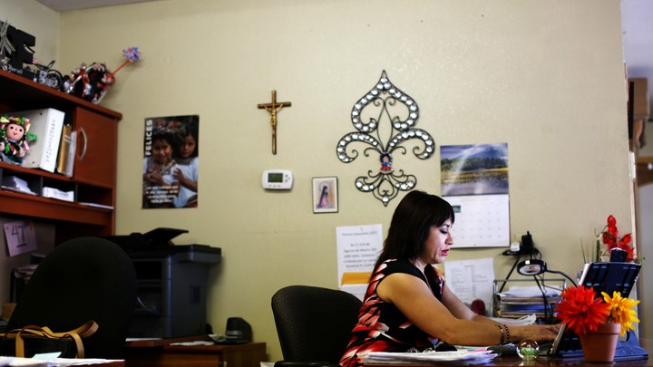 A woman sits at a desk in an office