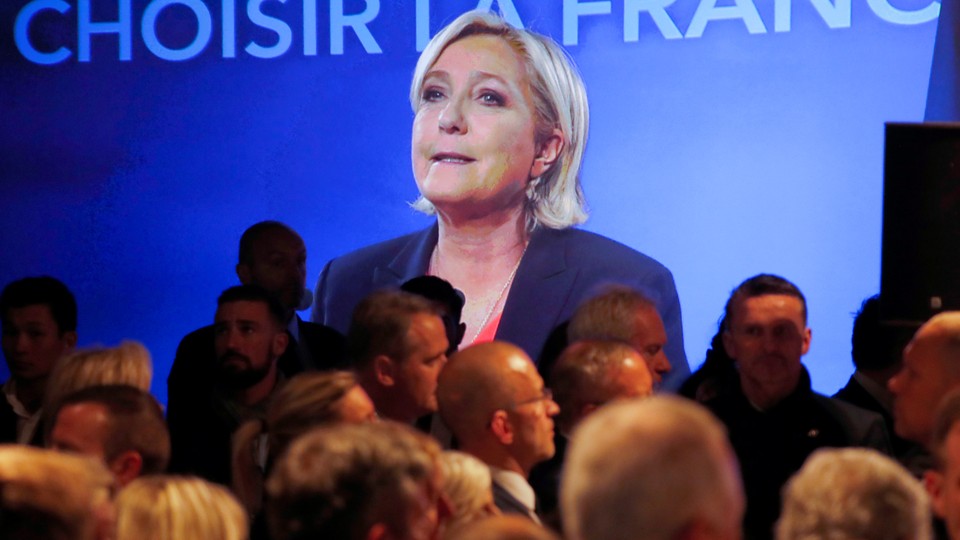 Marine Le Pen, French National Front (FN) political party candidate for French 2017 presidential election, is seen on a screen while conceding defeat.