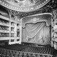 A black-and-white image of a grand old theater with many layers of balconies