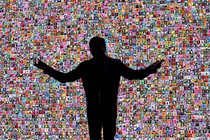 A photo of Jensen Huang in silhouette in front of a mosaic of small photos of flowers, delivering a keynote address at CES in 2018