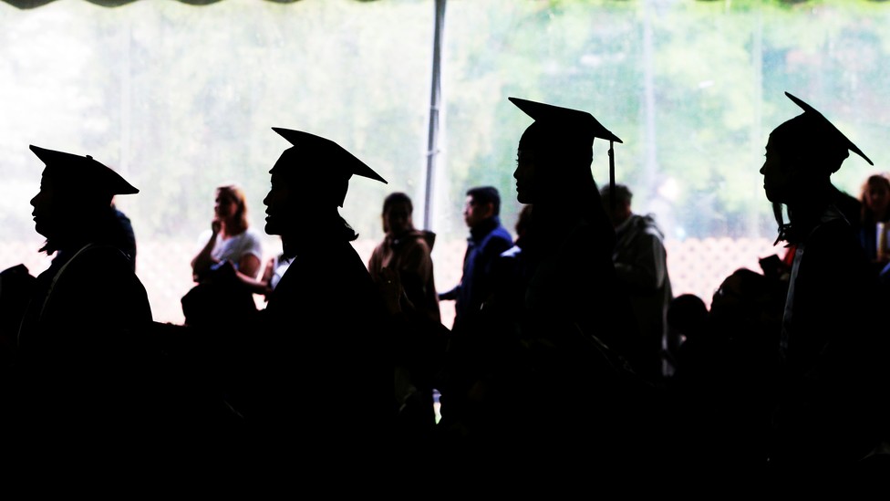 Female college graduates stand in a line.