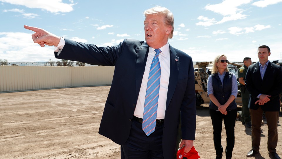 Donald Trump speaks next to then-DHS Secretary Kirstjen Nielsen as he visits the U.S.-Mexico border wall in Calexico, California, U.S., April 5, 2019.