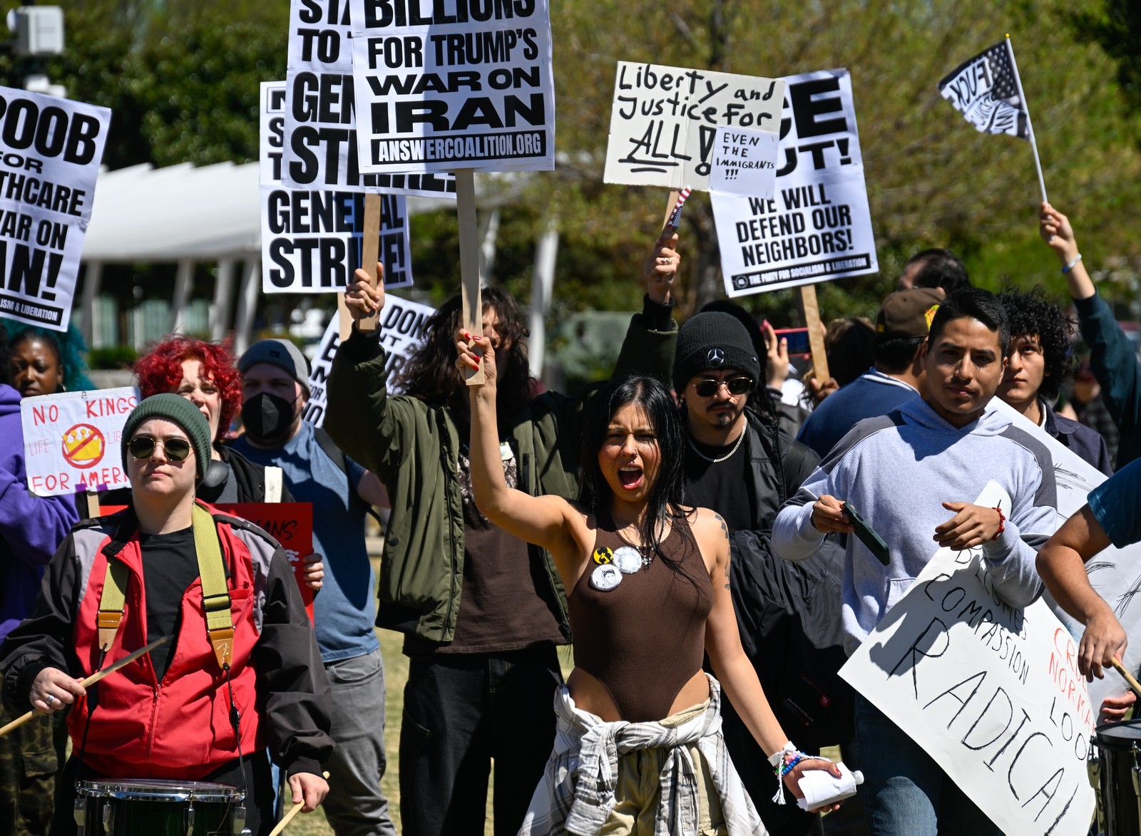 Protesters march, carry signs, and shout.