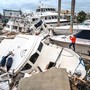 A person takes photos of piles of storm-damaged boats.