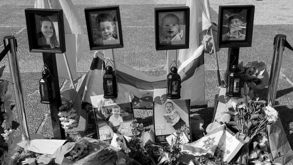 A memorial with photos of Shiri, Ariel, and Kfir Bibas and Oded Lifshitz in Tel Aviv