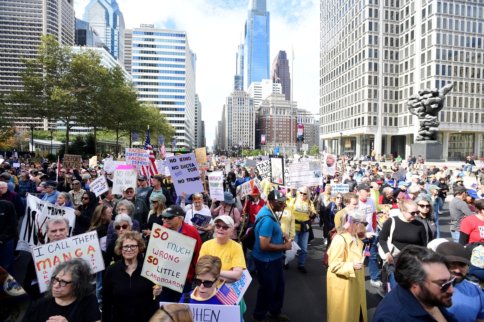 A large crowd of protesters gather in a city square in Philadelphia.