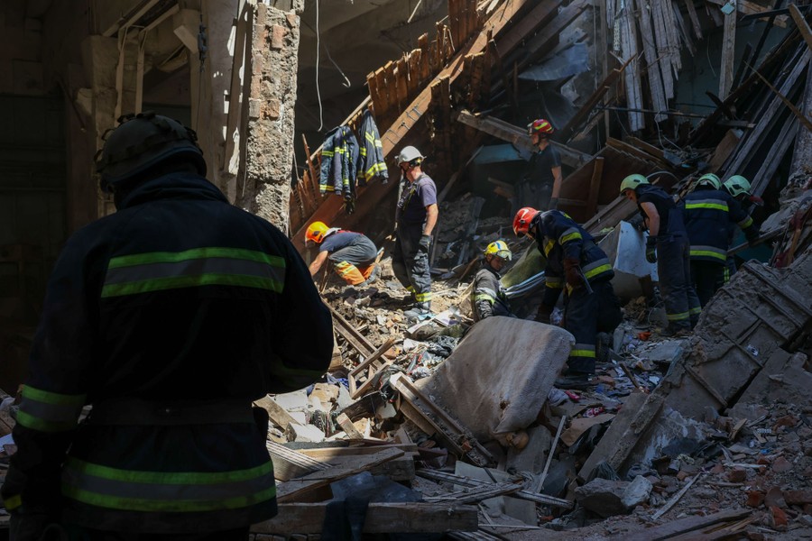 Several members of a search-and-rescue team work in a pile of rubble.