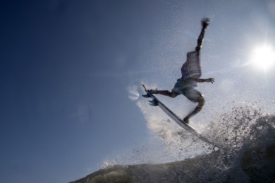 A surfer leaps from a wave.