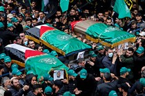 A crowd bears up Palestinian-flag-draped coffins at the funeral of Saleh al-Arouri