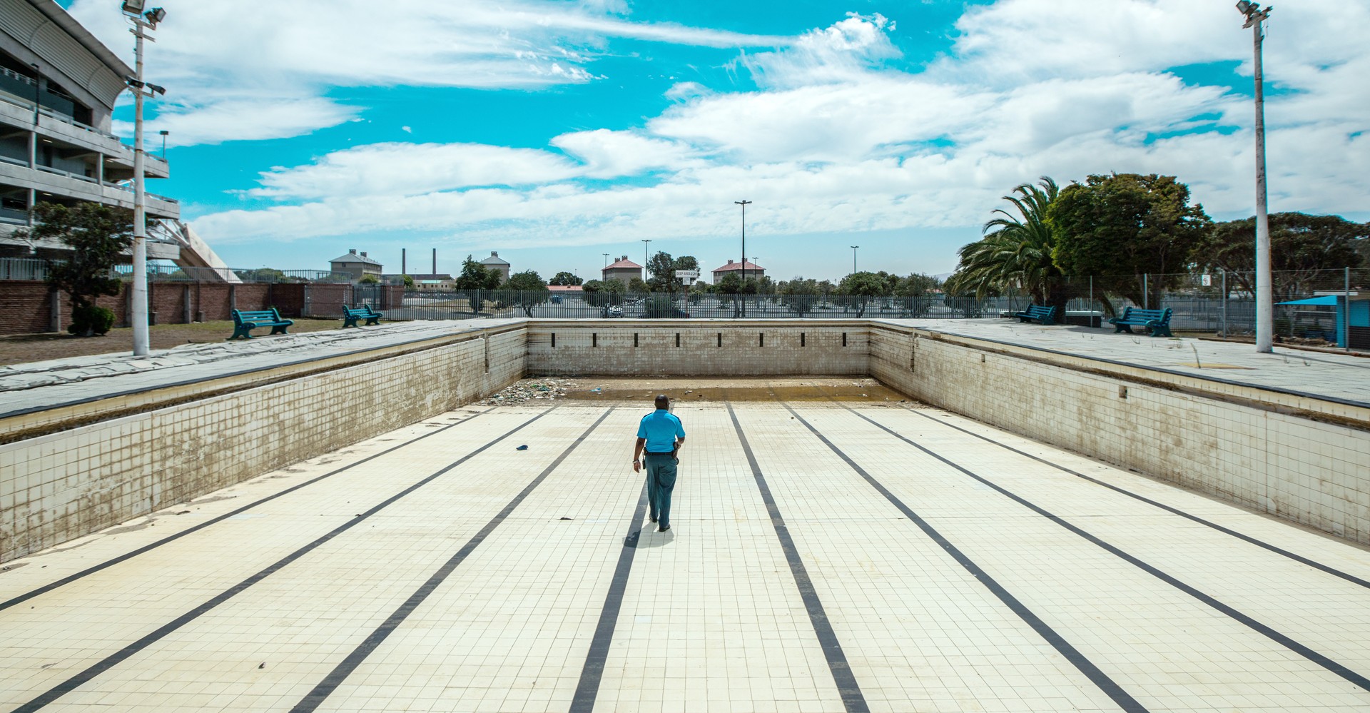 A man walks along the bottom of an empty public swimming pool near Cape Town.