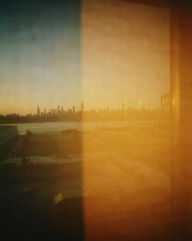 a hazy yellow view of a city skyline out of a window