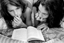 black and white photo of two girls reading a book