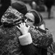 A Ukrainian soldier hugs his partner next to a military base where residents are queuing to join the army in Lviv.