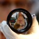 A technician is reflected in a 50-mm Leica Noctilux lens.