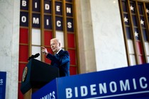 Joe Biden speaking above a "Bidenomics" sign