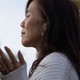 Two scenes from a vigil at Monterey Park City Hall: A woman with eyes closed and a bouquet of flowers