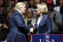 Betsy DeVos and Donald Trump shake hands