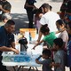 Groups of migrants receive food outside the Migrant Resource Center in Texas. 