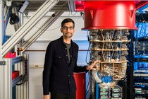 Google CEO Sundar Pichai stands beside a quantum computer.