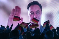 Photo of a crowd holding German flags watching a screen with Elon Musk waving