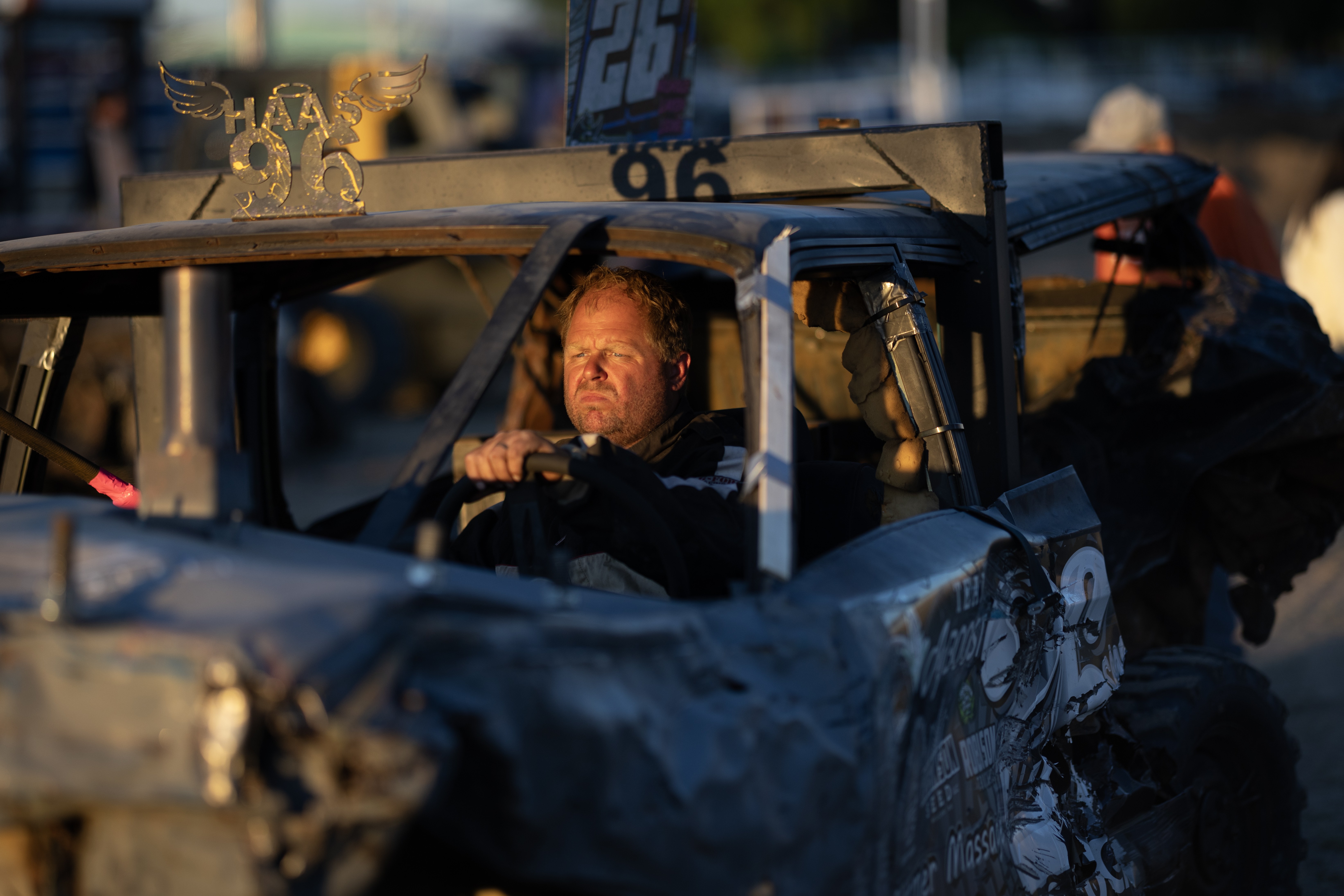 A man drives a smashed car during a demolition derby.