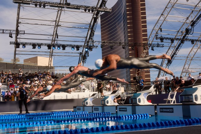 Swimmers diving into a pool
