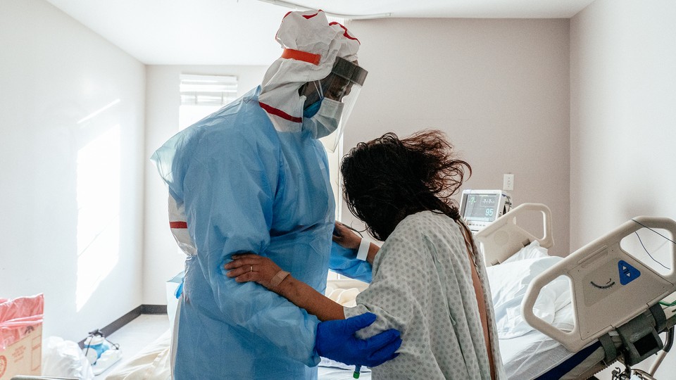 Medical staff member Marvin Alexander (L) gives a physical exercise to a patient in the COVID-19 intensive care unit (ICU) on Christmas Eve at the United Memorial Medical Center on December 24, 2020 in Houston, Texas. According to reports, Texas has reached over 1,650,000 cases, including over 26,600 deaths.