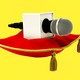 An illustration of a microphone sitting on a velvet pillow.