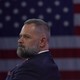 Rep. Cory Mills sits in front of a large American flag