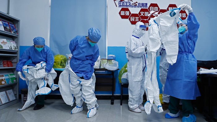 Medical workers put on protective suits