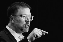 A black-and-white photo of Ben Wikler talking and pointing