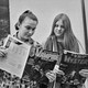Two teenage girls reading comic books