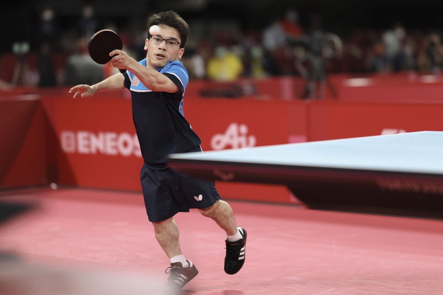 An athlete returns a volley during a gold-medal table-tennis match.
