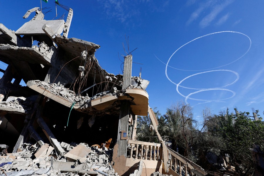 A spiral contrail, seen in the sky above destroyed houses