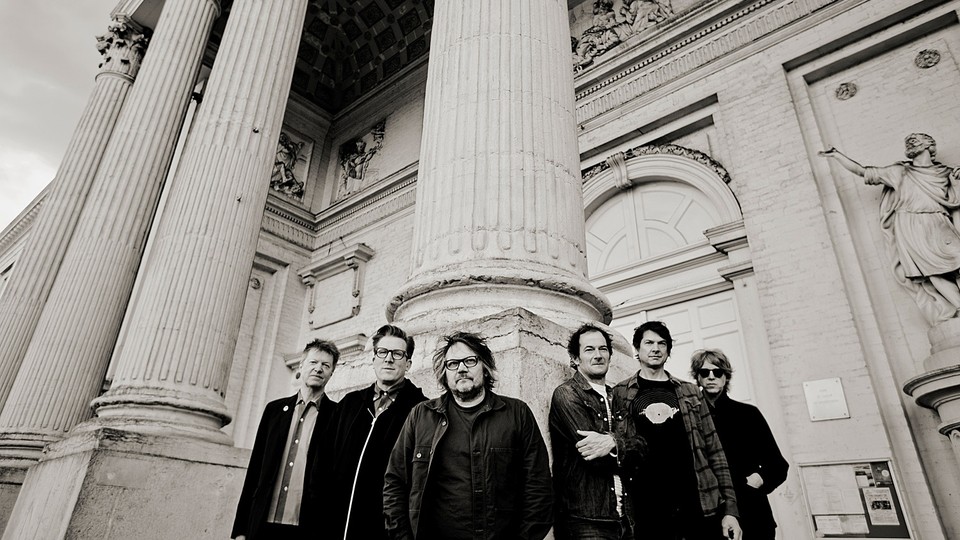 Wilco in monochrome next to large columns
