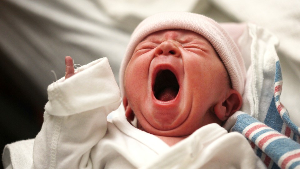 A baby yawns in a hospital.