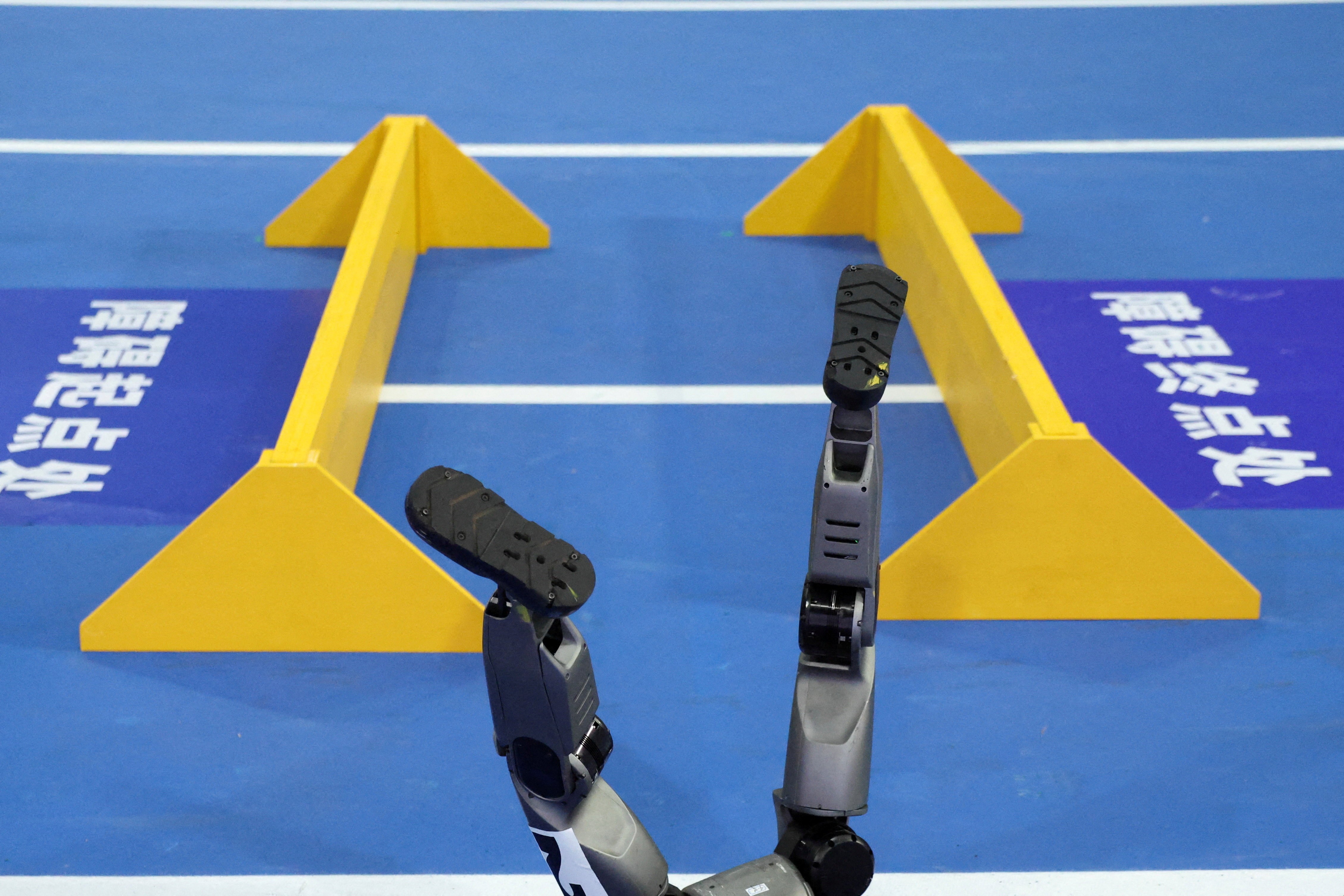 The feet of a humanoid robot stick up, after it fell during an obstacle race.