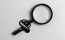 A magnifying glass with its handle tied in a knot