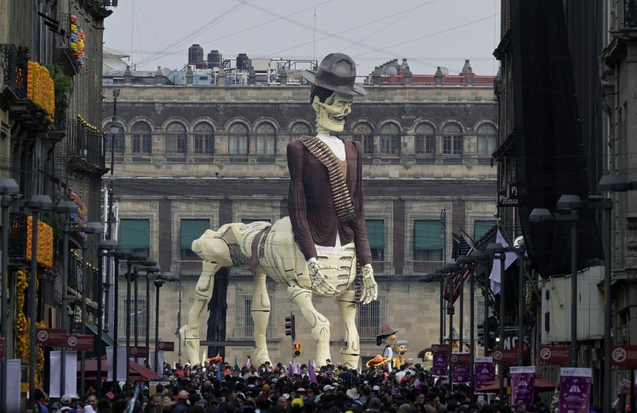 A sculpture of a skeleton centaur dressed in a brown jacket and wide-brimmed hat, with a bandolier slung across his torso