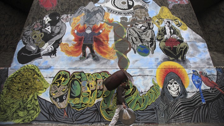A worker walks past graffiti denouncing the Interior Ministry and the Egyptian uprising.