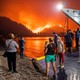 People board a ferry prior to an evacuation as a wildfire approaches the seaside village of Limni, on the island of Evia, Greece, on August 6, 2021.