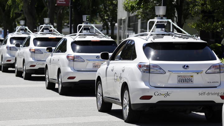 A row of Google self-driving Lexus cars at a Google event outside the Computer History Museum in Mountain View, California.