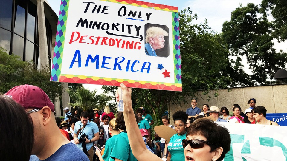 A protester carries an anti-Trump sign