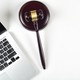A gavel rests next to a laptop keyboard.