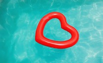 A red heart-shaped floaty in a blue pool