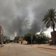 Picture of desolate urban street in Sudan, clouds of smoke in visible in the background