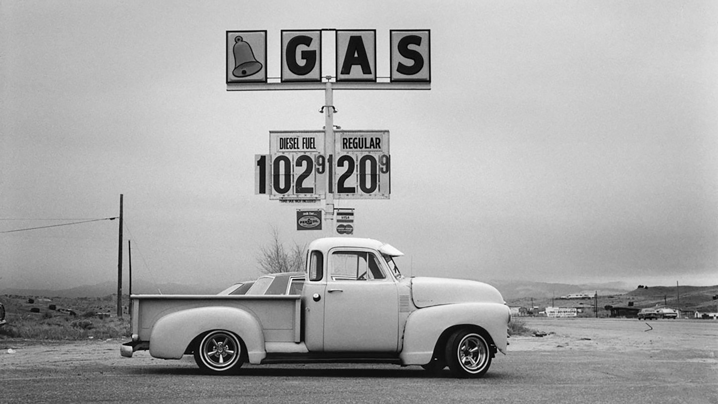 A truck parked in front of a gas sign.